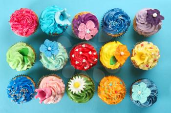 Delicious cupcakes on color background�