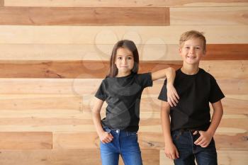 Cute children in t-shirts on wooden background�