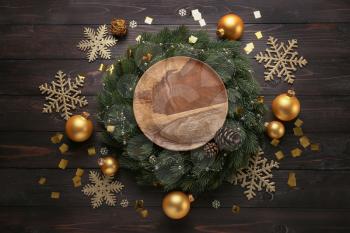 Composition with beautiful Christmas decorations and plate on wooden table�