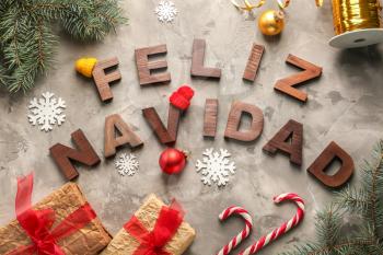 Words FELIZ NAVIDAD made with wooden letters and Christmas decorations on grey background�