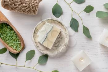 Composition with burning candles, eucalyptus branches, sea salt and soap bar on white background�