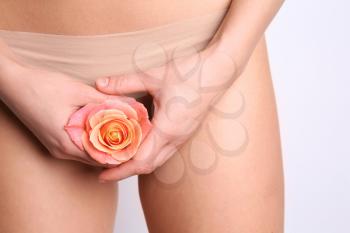 Sexy young woman holding rose near her panties, closeup. Erotic concept�