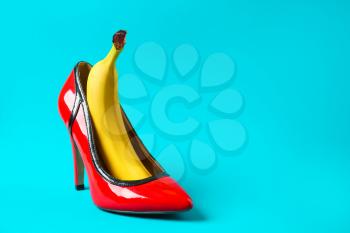 High heel shoe and banana on color background. Erotic concept�