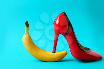 High heel shoe and banana on color background. Erotic concept�