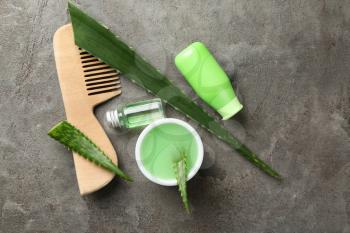 Flat lay composition with aloe leaves and natural cosmetics for hair on grey background�