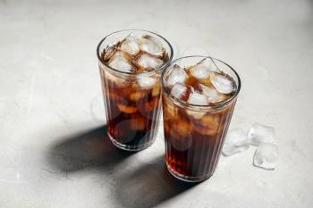 Glasses of tasty soda with ice on table�