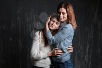Portrait of happy mother and daughter on dark background�
