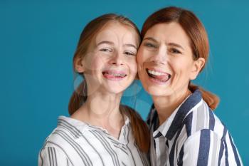 Portrait of funny mother and daughter on color background�