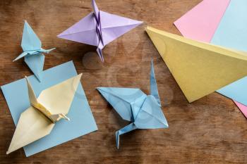 Origami cranes on wooden table�