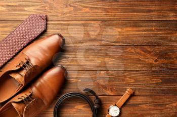Stylish male accessories on wooden background�