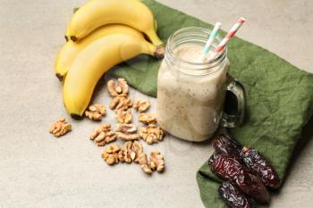 Mason jar of smoothie with dates, bananas and nuts on table�