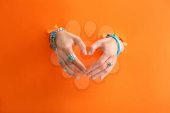 Hands of beautiful young woman with stylish bijouterie on color background�