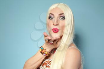 Portrait of young transgender man blowing kiss on color background�