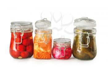 Jars with tasty fermented vegetables on white background�