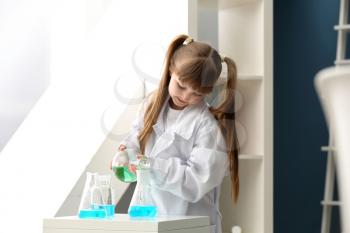 Cute little girl dressed as laboratory worker playing at home�