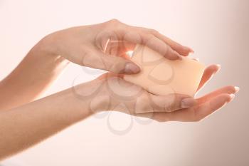 Female hands with soap bar on light background�