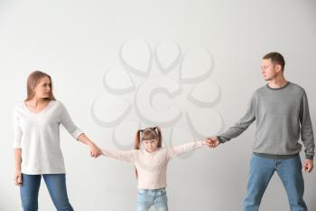 Divorced parents arguing about child custody on light background�