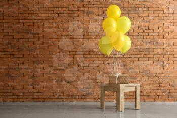 Table with birthday balloons and gift box in room�