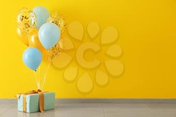 Birthday balloons with gift box in room�