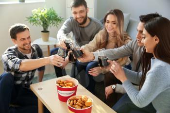 Group of friends eating nuggets and drinking soda at home�