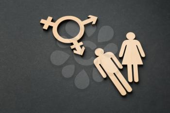 Female and male figures with symbol of transgender on dark background�