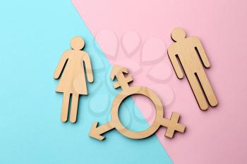 Female and male figures with symbol of transgender on color background�