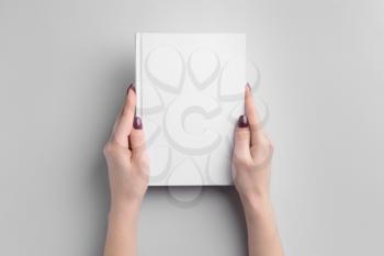 Female hands with book on light background�