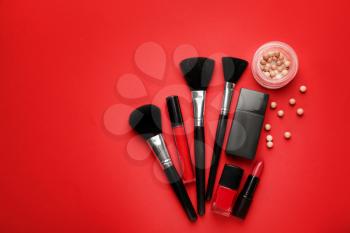 Set of makeup brushes and cosmetics on color background�
