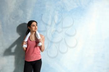 Sporty young woman on color background�