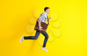 Running man with briefcase on color background�