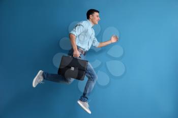 Running man with briefcase on color background�