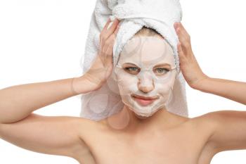 Beautiful young woman with sheet facial mask on white background�