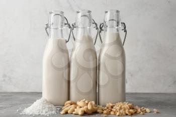 Assortment of tasty vegan milk on grey table�