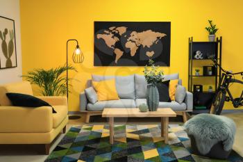 Stylish interior of room with picture of map on wall�