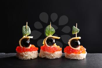 Tasty canapes on dark background�
