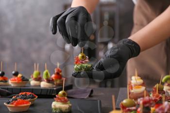 Chef preparing tasty canapes for serving�