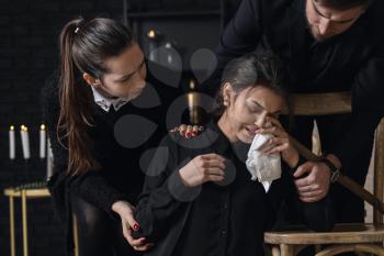 Relatives calming young widow at funeral�
