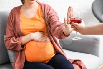 Pregnant woman rejecting alcohol at home�