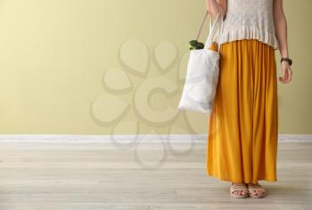 Young woman with fresh products in eco bag indoors�