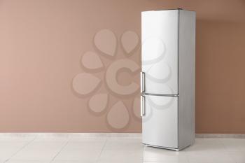 Modern fridge near color wall�