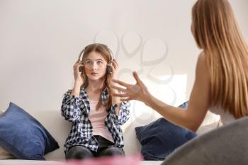 Sad teenage girl having argument with her mother at home�