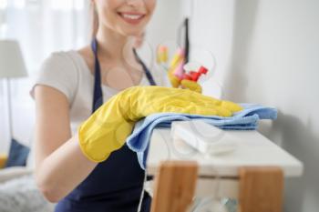 Female janitor cleaning shelf in room, closeup�