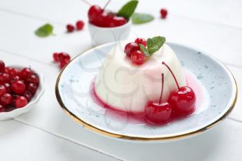 Plate with tasty panna cotta on white table�