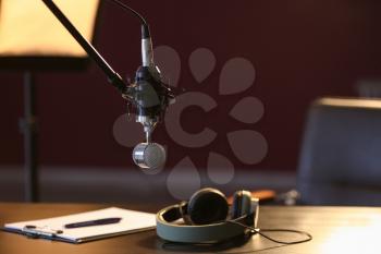Table with headphones and microphone in radio station�