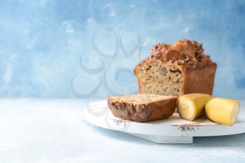 Board with tasty banana bread on color background�