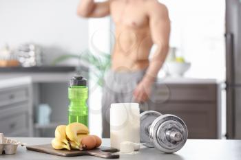 Ingredients for protein shake and dumbbell on table�