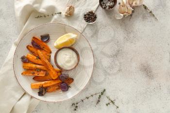Plate with tasty cooked carrot and sauce on grey table�