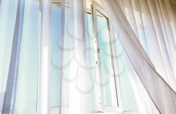 Open window with light curtains in room�