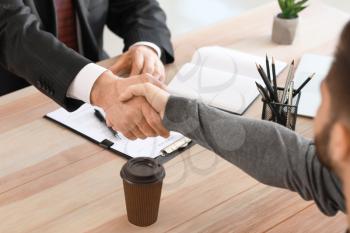Man shaking hand of notary public in office�