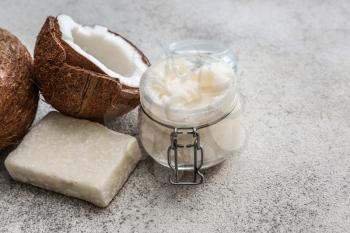 Jar of coconut oil and soap on light background�